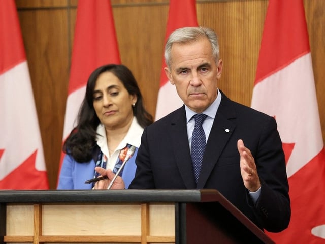 Canadian Prime Minister Mark Carney (R), flanked by Canadian Foreign Affairs Minister Anita Anand, speaks during a press conference on July 30, 2025.