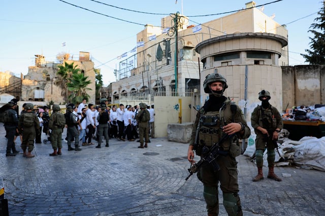 Israeli troops stand guard during a weekly settlers' tour in Hebron, in the Israeli-occupied West Bank, on August 30.