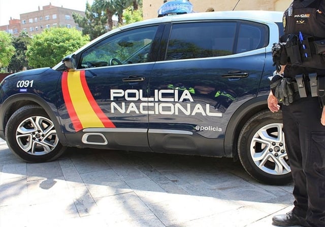 Un agente de Policía con su vehículo