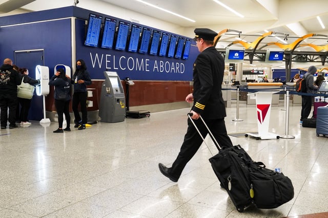 A pilot walks past people checking in for their flights at the airport ahead of the Thanksgiving Holiday at Hartsfield-Jackson Atlanta International Airport, in Atlanta, Georgia, U.S., November 27, 2024.   REUTERS/Megan Varner/File Photo