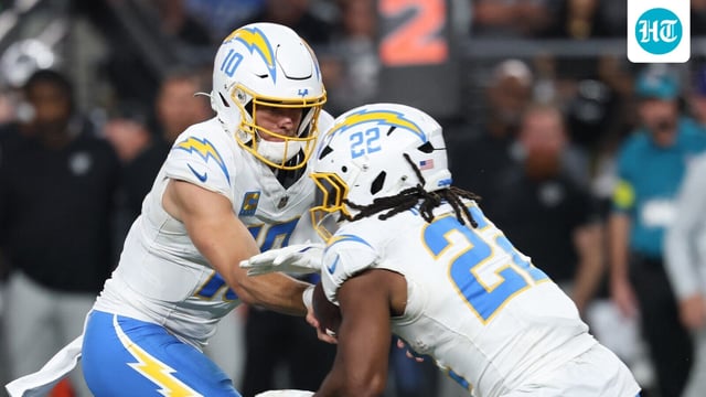 Los Angeles Chargers quarterback Justin Herbert (10) hands the ball off to Najee Harris (22)