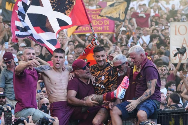 Lorenzo Pellegrini y Gianluca Mancini de la Roma celebran con los aficionados el triunfo en el derbi ante la Lazio en la Serie A el domingo 21 de septiembre del 2025.(AP Foto/Alessandra Tarantino)
