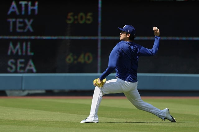 Dodgers pitcher Roki Sasaki throws in the outfield before the Dodgers host the Minnesota Twins in a baseball game Tuesday, July 22, 2025, in Los Angeles. (AP Photo/Eric Thayer)