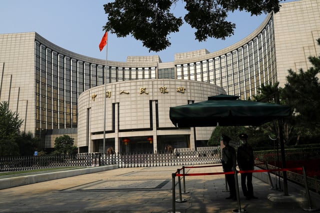Paramilitary police officers stand guard in front of the headquarters of the People's Bank of China, the central bank (PBOC), in Beijing, China September 30, 2022. REUTERS/Tingshu Wang/File Photo