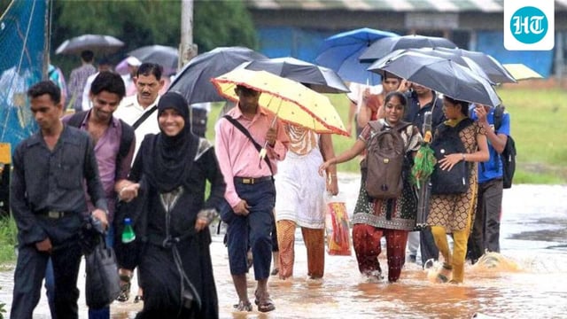 People walk through a flooded road following heavy rains in Mumbai. (PTI Photo/Shashank Parade)