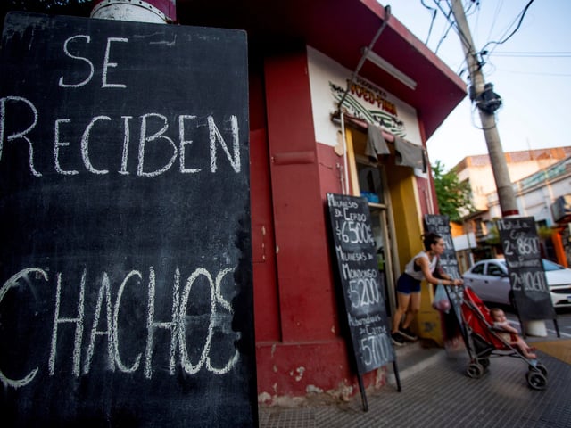 A sign reads in Spanish, "We take chachos" at a butcher shop in La Rioja, Argentina, Monday, Sept. 23, 2024. In response to slashed federal budgets to provinces, La Rioja is printing a new emergency tender called "chachos" to pay state workers and spur the economy. (AP Photo/Natalia Diaz)