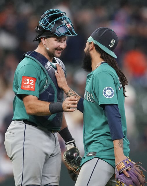 Seattle Mariners shortstop J.P. Crawford, right, celebrates with catcher Cal Raleigh after defeating Houston 7-3 during a MLB baseball game in Houston, Sunday, Sept. 21, 2025. Crawford hit a grand-slam off Houston Astros starting pitcher Jason Alexander, while Raleigh hit a 2-run home run  in the second inning.