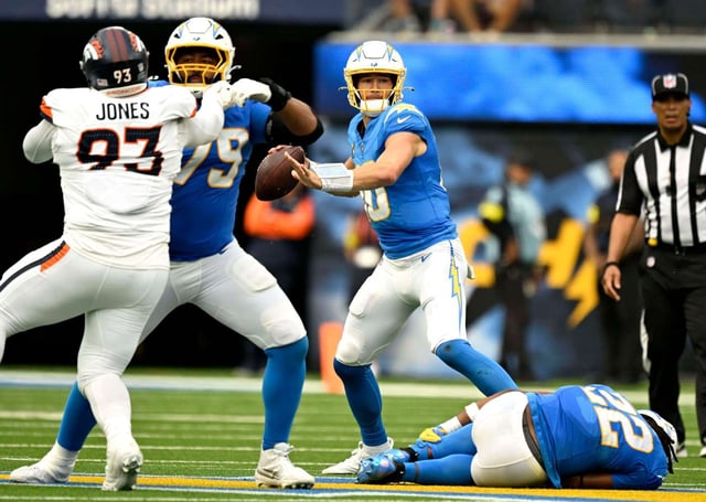Chargers quarterback Justin Herbert (10) looks to through down field as running back Najee Harris (22) lies injured during the first half against visiting Denver at SoFi Stadium in Inglewood on Sunday, Sept. 21, 2025. The Los Angeles Chargers host the Denver Broncos in a National Football League (NFL) game in their season home opener. (Photo by Will Lester, Inland Valley Daily Bulletin/SCNG)