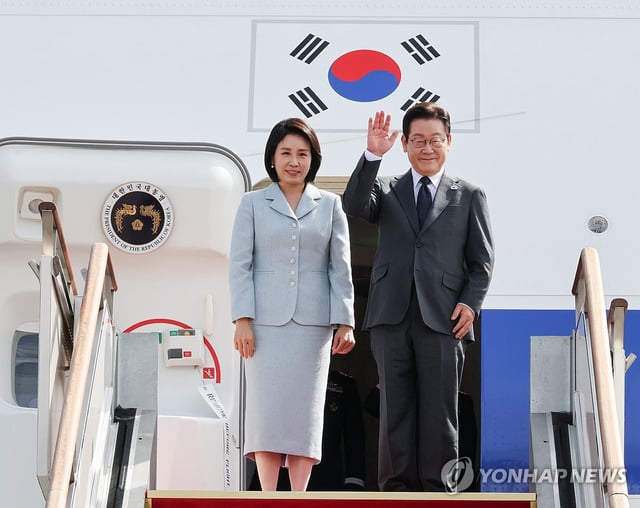 President Lee Jae Myung (R) waves as he and first lady Kim Hea Kyung prepare to board the presidential jet bound for New York to attend the U.N. General Assembly on Sept. 22, 2025, at Seoul Airport in Seongnam, south of Seoul. (Yonhap)