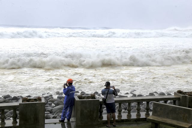 CORRECTS DATE - People watch as strong waves batter Basco, Batanes province, northern Philippines as Typhoon Ragasa affects the area on Monday, Sept. 22, 2025. (AP Photo/Justine Mark Pillie Fajardo)