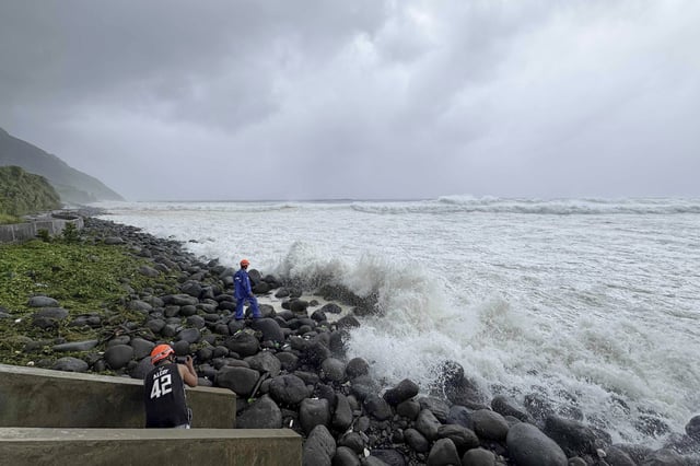 People watch as strong waves batter Basco, Batanes province, northern Philippines as Typhoon Ragasa affects the area on Monday, Sept. 22, 2025. (AP Photo/Justine Mark Pillie Fajardo)