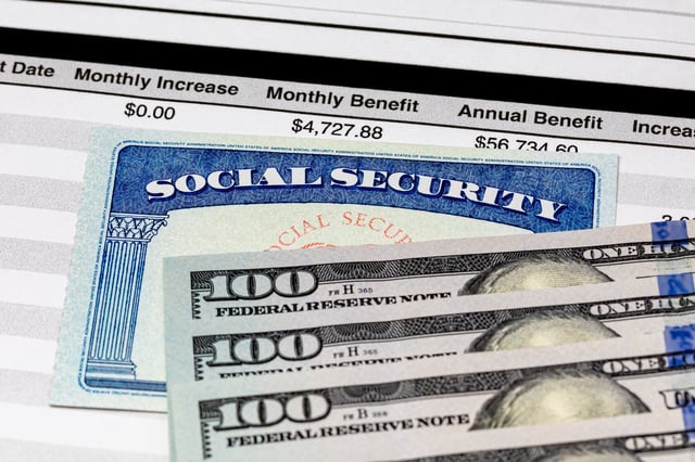 Stock image of a Social Security card with U.S. Dollar bills.