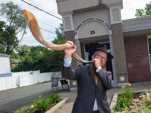 Rabbi Yosef Wolvovsky blows the shofar at The Harold Rothstein Chabad Jewish Center in Glastonbury in 2023. (Aaron Flaum/Hartford Courant)
