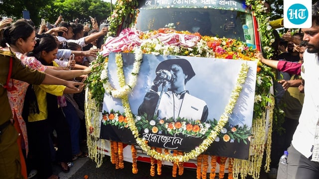 People touch the vehicle carrying the mortal remains of singer Zubeen Garg as they are taken to his residence from Guwahati airport.