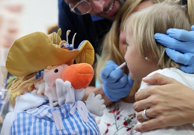 Una niña recibe la vacuna de la gripe