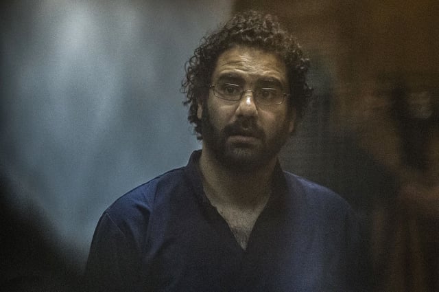 Egyptian activist and blogger Alaa Abdel Fattah looks on from behind the defendant's cage during his trial for insulting the judiciary alongside 25 other defendants including ousted Egyptian president Mohamed Morsi, who was recently sentenced to death, in Cairo on May 23, 2015. AFP PHOTO / KHALED DESOUKI        (Photo credit should read KHALED DESOUKI/AFP via Getty Images)