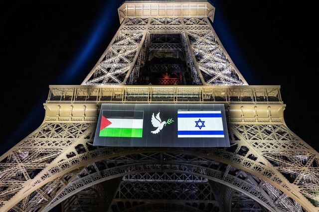 Esta fotografía muestra imágenes de banderas palestina e israelí y una paloma con una rama de olivo, proyectadas sobre la Torre Eiffel en vísperas del reconocimiento previsto por Francia del Estado de Palestina, en París, el 21 de septiembre de 2025