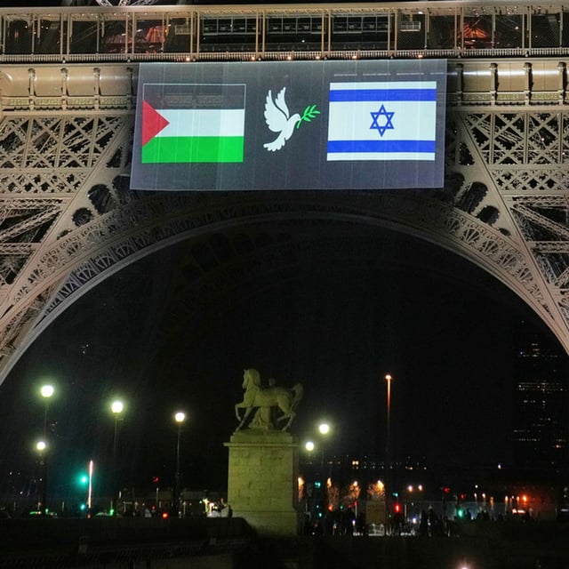 A large screen displays Palestinian and Israeli flags and a dove on the Eiffel Tower, Sunday, Sept. 21, 2025, in Paris, as France prepares to formally recognize a Palestinian state at the United Nations General Assembly. (AP Photo/Christophe Ena)
