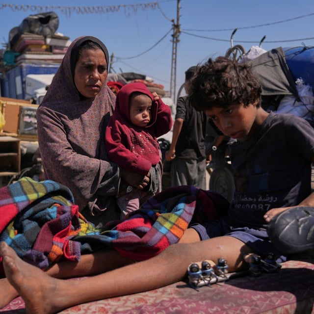 Amal Al-Qishawi, follows her injured son, Yasser, 11, carried on a bicycle by his father Rafiq Al-Qishawi, as they flee northern Gaza Strip walking along the coastal road, near Wadi Gaza, Saturday, Sept. 20, 2025. (AP Photo/Abdel Kareem Hana)