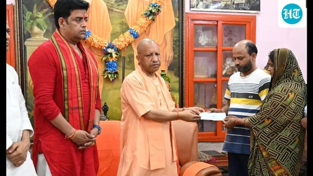 Uttar Pradesh CM Yogi Adityanath giving ₹5 lakh cheque to the parents of the youth killed by cattle smugglers in Gorakhpur. (HT photo)
