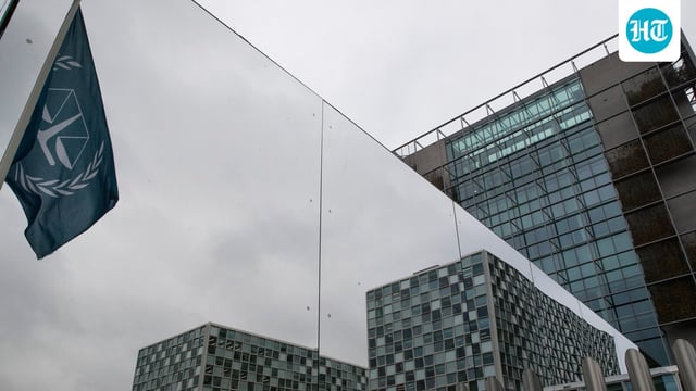 The flag of the International Criminal Court is reflected in a mirrored wall of the building in The Hague, Netherlands.