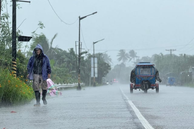 Stock Image: A man walks along a road amid heavy rain due to weather patterns from Super Typhoon Ragasa in Lal-lo town, Cagayan province, on September 22.