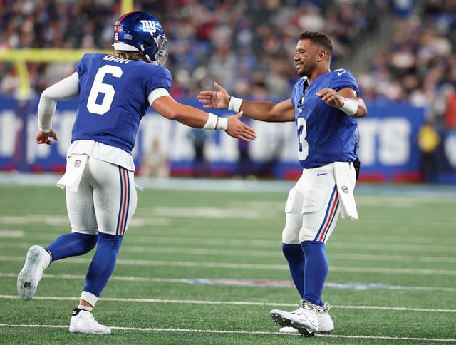 Jaxson Dart #6 of the New York Giants celebrates a touchdown against the New England Patriots with Russell Wilson #3 during their NFL Preseason game at MetLife Stadium on August 21, 2025 in East Rutherford, New Jersey.