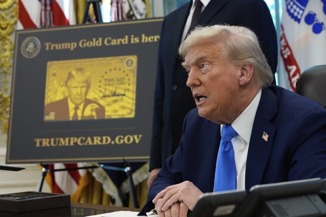 A poster showing the Trump Gold Card is seen as President Donald Trump signs executive orders in the Oval Office of the White House, Friday, September 19, 2025, in Washington.