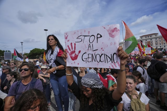 Personas sostienen pancartas con la leyenda "Alto al genocidio" mientras participan en una manifestación como parte de una protesta nacional y huelga general contra la guerra en Gaza, en Roma, el lunes 22 de septiembre de 2025