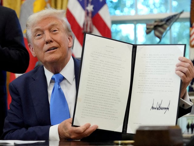 El presidente de Estados Unidos, Donald Trump, muestra una orden ejecutiva firmada en una tarjeta Visa dorada en la Oficina Oval de la Casa Blanca en Washington. Foto Reuters