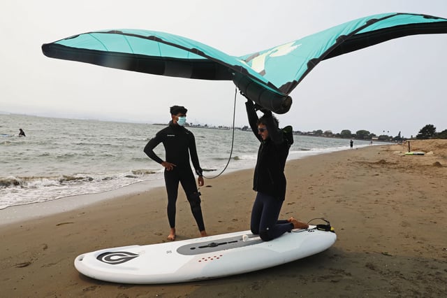 Mayank K., 32, left, of the South Bay, listens to instructor Matthew Jackson, 29, with Boardsports California, during a winging lesson on Alameda Beach. The Bay Area Air Quality Management District issued a Spare the Air alert for Tuesday.