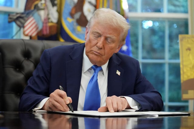 U.S. President Donald Trump signs an executive order in the Oval Office at the White House in Washington, D.C., U.S., September 19, 2025. REUTERS/Ken Cedeno/File Photo