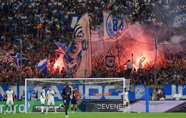 Soccer Football - Ligue 1 - Olympique de Marseille v Paris St Germain - Orange Velodrome, Marseille, France - September 22, 2025 General view of fans with flares and flags inside the stadium REUTERS/Alexandre Dimou
