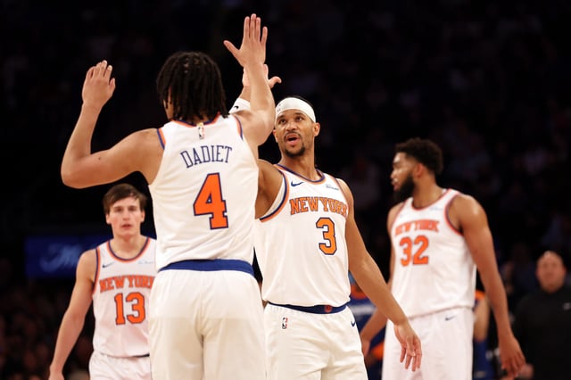 Josh Hart #3 reacts with Pacome Dadiet #4 of the New York Knicks during the first half against the Washington Wizards at Madison Square Garden on November 18, 2024 in New York City.