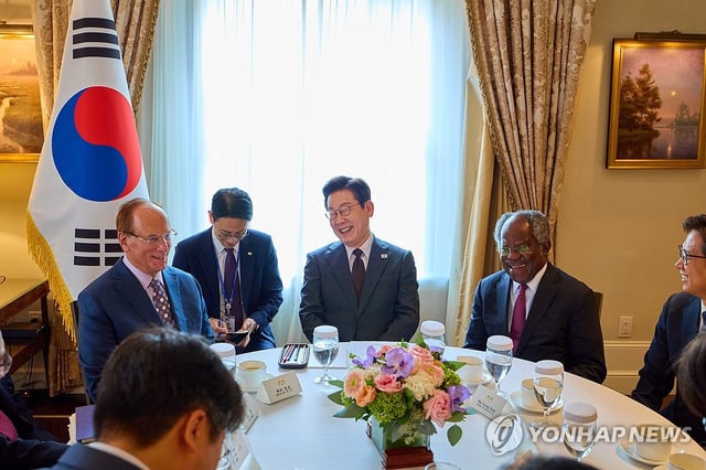 President Lee Jae Myung (C) speaks with BlackRock CEO Larry Fink (L) at a hotel in New York on Sept. 22, 2025. (Pool photo) (Yonhap)