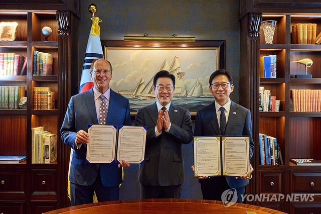 President Lee Jae Myung (C) poses for a photo with Bae Kyung-hoon (R), minister of science and ICT, and BlackRock CEO Larry Fink after Bae and Fink signed a memorandum of understanding on an artificial intelligence partnership on Sept. 22, 2025. (Pool photo) (Yonhap) 