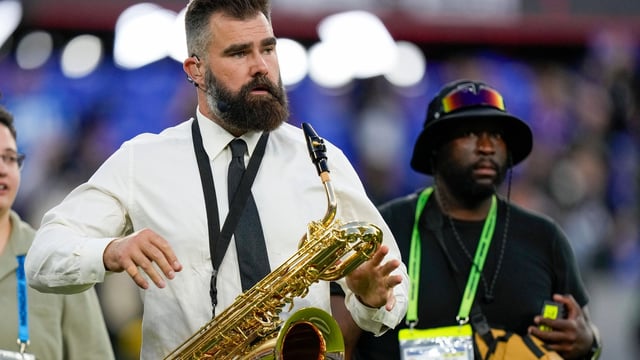 Former Philadelphia Eagles player Jason Kelce holds an instrument prior to an NFL football game between the Baltimore Ravens and the Detroit Lions.