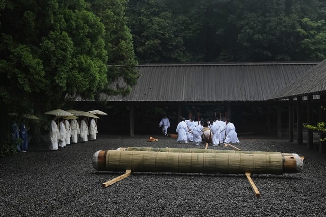 Shinto officials in the priesthood use wooden poles to move sacred timbers under the roof at the end of Mihishirogi Hoeishiki, a ceremony of the Shikinen Sengu ritual to rebuild main structures of the Jingu shrine complex for Shinto deities, in Ise, central Japan, June 10, 2025. (AP Photo/Hiro Komae)
