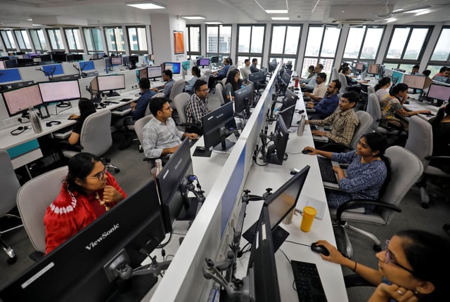 Employees work on their terminals inside the office of Manubhai & Shah LLP, a local accounting firm, in Ahmedabad, India, July 4, 2023. REUTERS/Amit Dave/File Photo