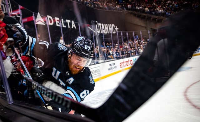 Utah Hockey Club left wing Lawson Crouse (67) slams into the glass with New Jersey Devils defenseman Johnathan Kovacevic (8) during an NHL game against the New Jersey Devils held at the Delta Center in Salt Lake City on Saturday, March 1, 2025.