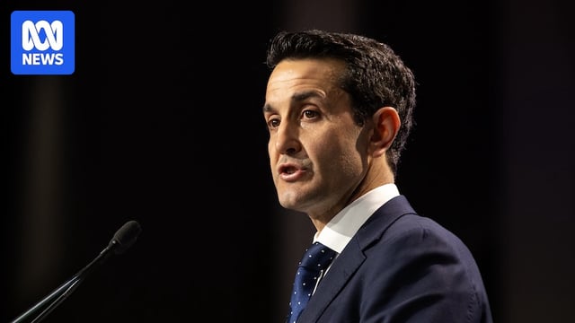 David Crisafulli stands with a microphone in front of him speaking,