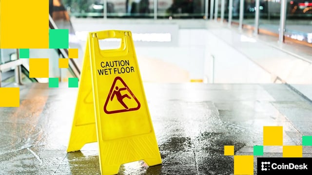 A sign warning of a danger of slipping stands on a wet floor. (zhu difeng/Shutterstock)