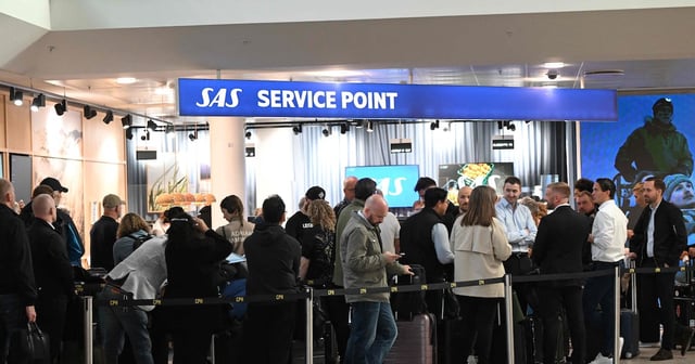 Passengers queue for new tickets after flights were cancelled due to drones flying over Copenhagen Airport. AFP