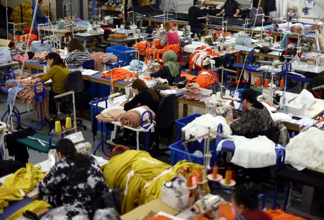 Machinists are seen at work on the factory floor of Fashion-Enter Ltd in London, Britain, February 15, 2023. REUTERS/Hannah McKay/File Photo