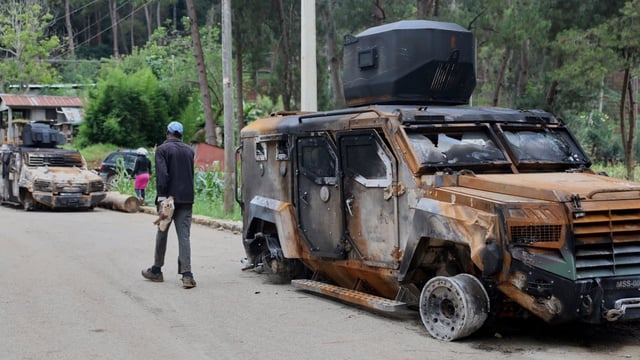A man walks past an armoured vehicle used by Kenyan police that, according to police, was burned during an attack by armed gangs in Port-au-Prince, Haiti, on Aug. 14. The transitional government on Monday had not commented on a deadly weekend drone attack.