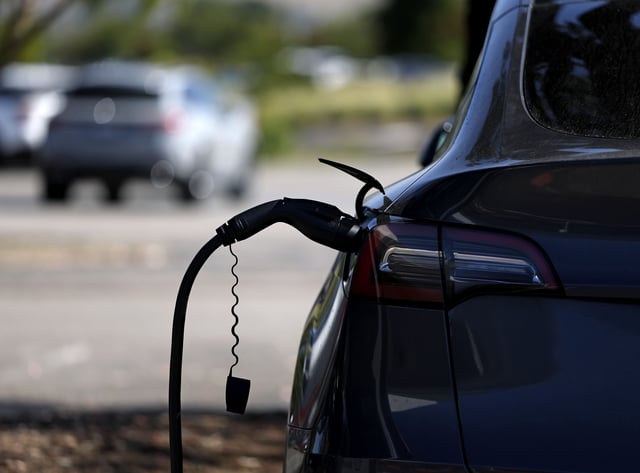 A Tesla car sits parked at an electric vehicle charging station on June 12, 2025 in Corte Madera, California.