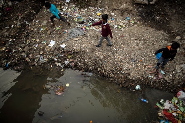 Boys play near an open sewer at a slum in Islamabad March 12, 2015. REUTERS/Zohra Bensemra/File Photo