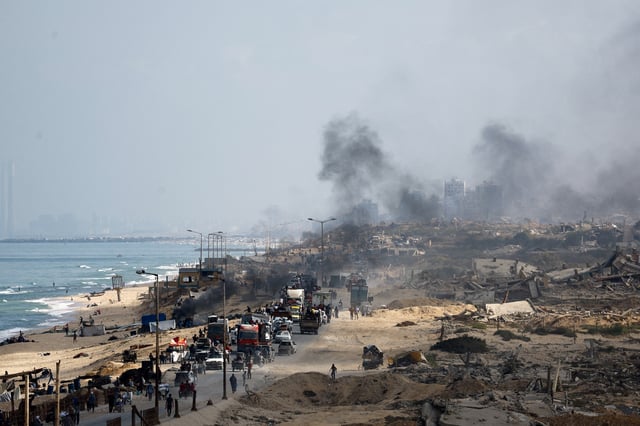 Displaced Palestinians, fleeing northern Gaza due to an Israeli military operation, move southward along a destroyed area after Israeli forces ordered residents of Gaza City to evacuate to the south, in the central Gaza Strip, September 23, 2025. REUTERS/Mahmoud Issa