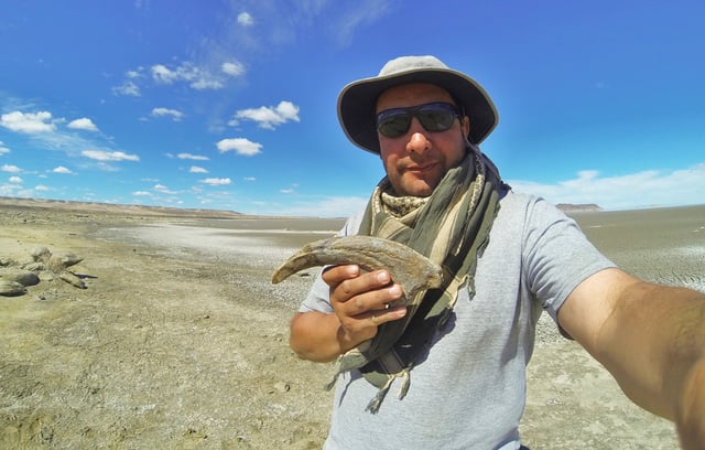 Researcher Marcelo Luna holds the claw of a close relative of the Cretaceous meat-eating dinosaur Joaquinraptor from the Lago Colhue Huapi Formation in Patagonia, Argentina, in this image released on September 23, 2025. Marcelo Luna/Handout via REUTERS