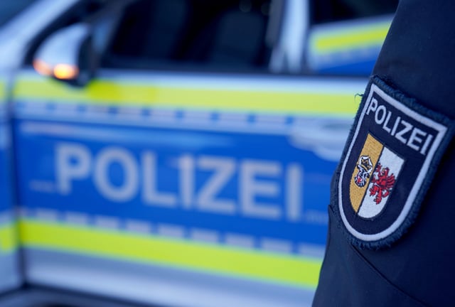 Eine Polizistin steht neben einem Einsatzfahrzeug. (Symbolbild)